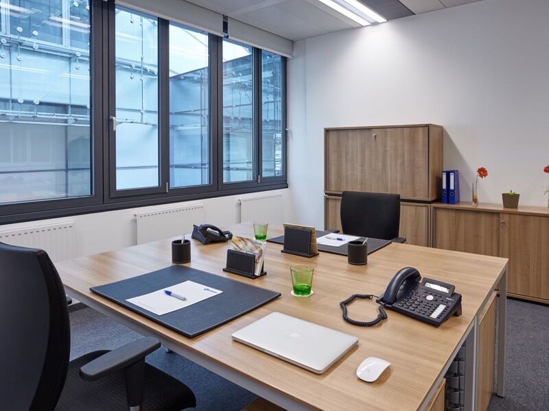 Geräumiges und modernes Büro mit Holztischen und großen Fenstern im Europlaza