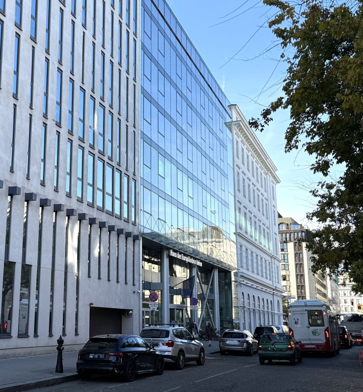 Außenansicht des Gebäudes Haus der Europäischen Union mit moderner Glasfassade und parkenden Autos auf der Straße