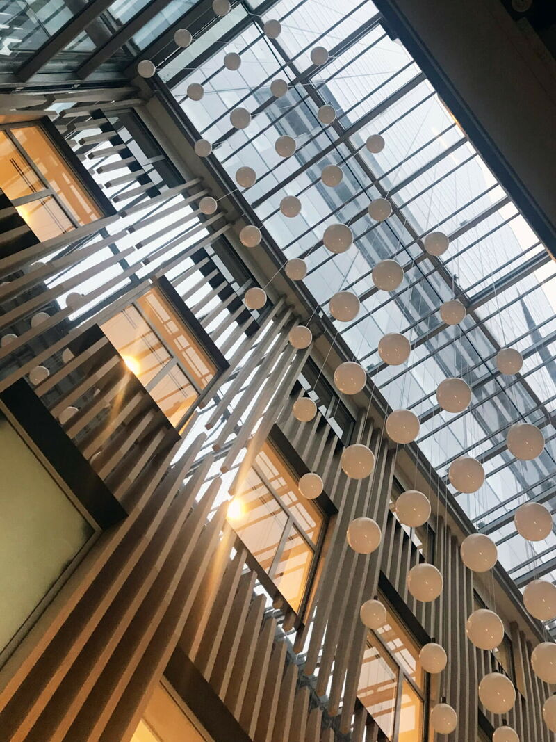 Innenansicht einer modernen Galerie mit Glas-Atriumdach und dekorativen hängenden weißen Kugeln