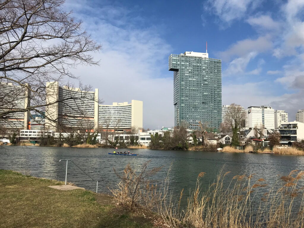 Rowing boat on the Old Danube with the IZD Tower and Vienna skyline in the background